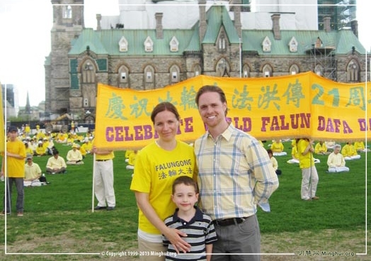 二零一三年五月八日，加拿大首都渥太华国会山前，德鲁与妻子及儿子在法轮大法传世二十一周年庆祝活动现场。（图片来源：明慧网）