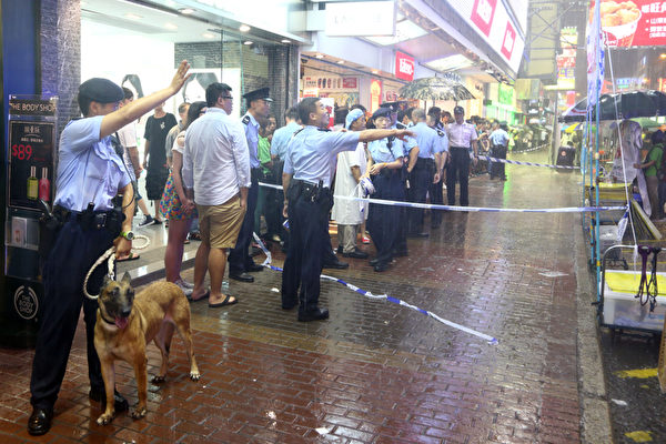 由于中共江泽民集团的的走狗梁振英的垂死挣扎，香港青关会恶徒7月14日再次暴力骚扰位于旺角行人专用区的法轮功真相点，上演了一场正邪大战；大批市民纷纷怒斥青关会的中共邪恶行径以及警方的纵容，图为警方在发生冲突后出动警犬维持秩序。（摄影：潘在殊／大纪元）