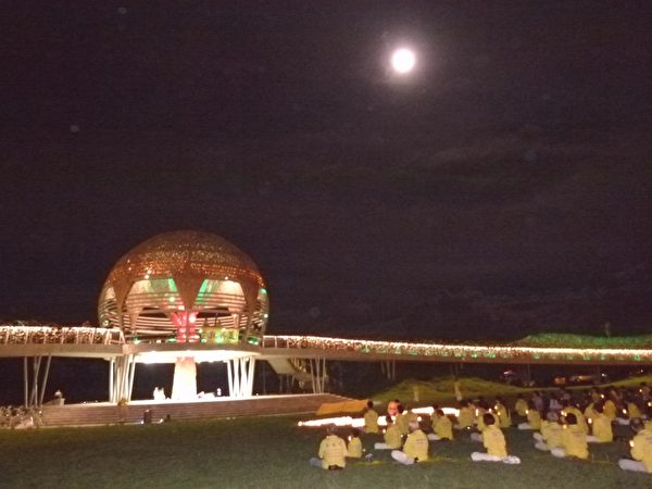 2013年7•20，台灣台東法輪功學員進行燭光夜悼，夜空中皎潔的月光與燭光相互輝映，見證人間的真誠善良永存。（龍芳／大紀元）