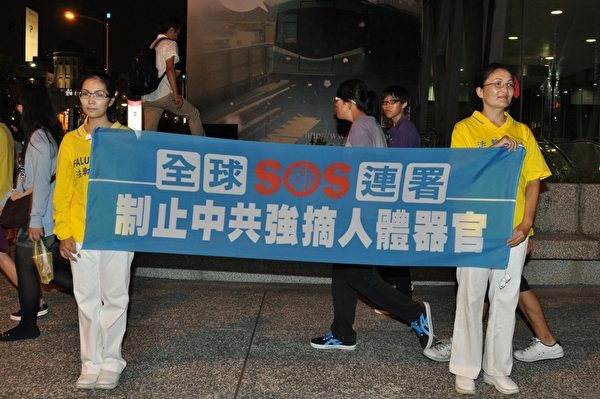 2013年7月20日，法輪功學員在街頭拉橫幅，向往來民眾講活摘器官真相。（李晴玳／大紀元）