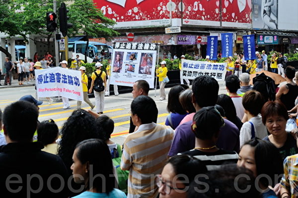 香港法轮功学员21日在长沙湾举行7.20法轮功反迫害14周年集会游行，队伍声势浩大沿途吸引许多中港民众观看。（摄影：宋祥龙／大纪元）