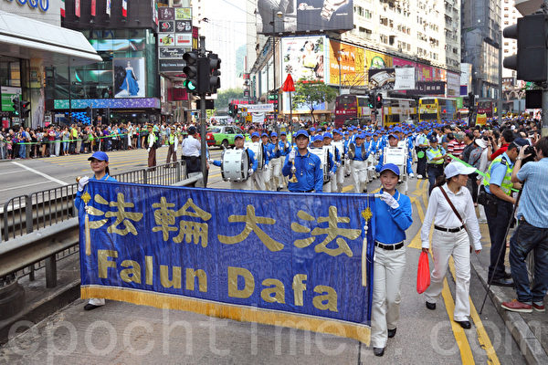 香港国殇日的集会结束后，800名游行人士手持各式横幅幡旗，从北角英皇道游乐场出发前往中共驻港联络办事处，浩浩荡荡的游行队伍吸引大批中港人士驻足观看。（潘在殊／大纪元）