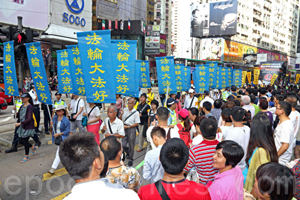 香港國殤日的集會結束後，800名遊行人士手持各式橫幅幡旗，從北角英皇道遊樂場出發前往中共駐港聯絡辦事處，浩浩蕩蕩的遊行隊伍吸引大批中港人士駐足觀看。（潘在殊／大紀元）