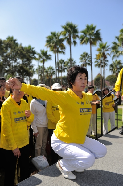 2013年10月20日，洛杉矶，集会上法轮功学员王春英演示中共迫害的酷刑（宋祥龙／大纪元）
