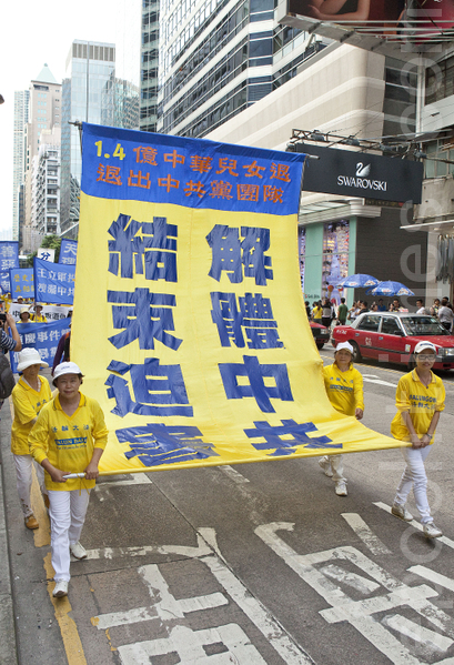 圖為今年香港法輪功學員舉行7.20法輪功反迫害14週年集會遊行，呼籲民眾解體中共，結束迫害，隊伍聲勢浩大沿途吸引許多中港民眾觀看。（攝影：余鋼／大紀元）