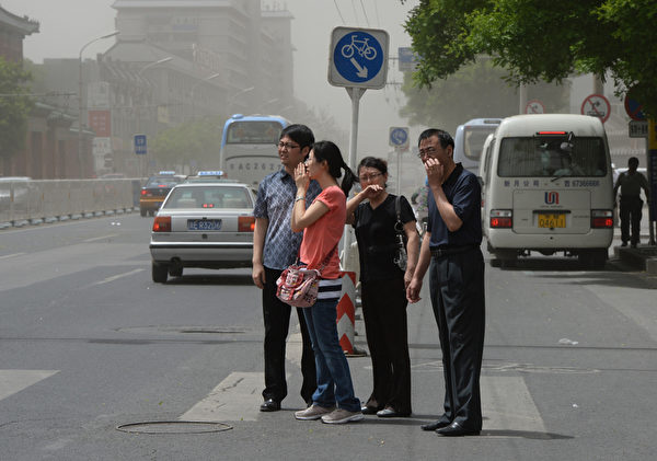 “十一”期间，北京的PM2.5数值达到296重度污染，大部分城区笼罩在雾霾之中，空气质量维持在5级重度污染。图为今年五月的北京街头，民众用手掩护口鼻。(Mark RALSTON/AFP)