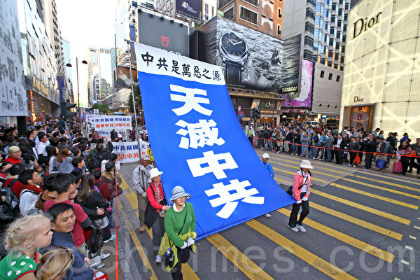 香港法轮功学员12月1日举行庆祝九评九周年及声援一亿五千万中国民众退出中共组织集会，游行队伍由九龙长沙湾游乐场出发，途经九龙区闹市，声势浩大的游行场面震撼许多大陆游客。（潘在殊/大纪元）