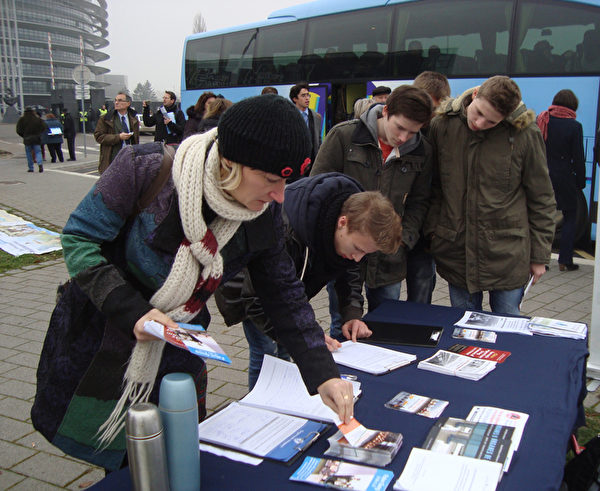 來歐洲議會的參觀者在信息台前簽名（攝影：黎平/大紀元）