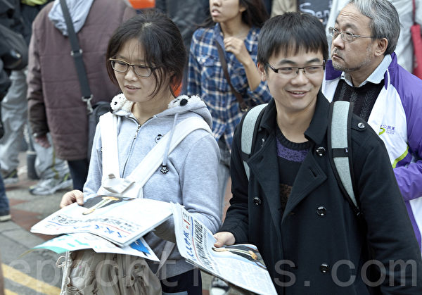 香港2014年新年大遊行於1月1日下午3時正式在維多利亞公園出發。大陸遊客也爭相拿《大紀元時報》，了解真相。（余鋼/大紀元）