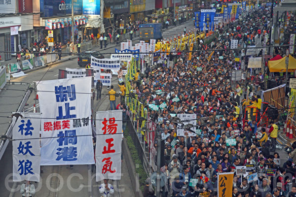香港民间人权阵线举行的2014年新年大游行，3万人参加，法轮功的游行队伍以雄壮的天国乐团演奏及各式揭露中共迫害和退党的幡旗横额，成为最受瞩目的阵列。（潘在殊／大纪元）