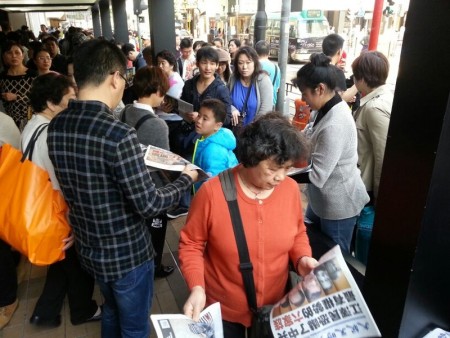 中國新年期間，大批大陸遊客擠爆香港。他們街頭巷尾拿大紀元閱讀，成為香港一大特殊景象。（大紀元圖片）