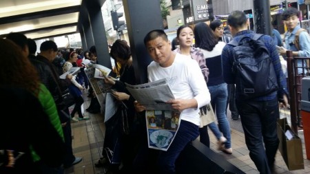 中国新年期间，大批大陆游客挤爆香港。他们街头巷尾拿大纪元阅读，成为香港一大特殊景象。（大纪元图片）