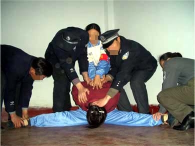 酷刑演示：強行將受害者的雙腿一字劈開 （圖片來源：明慧網）