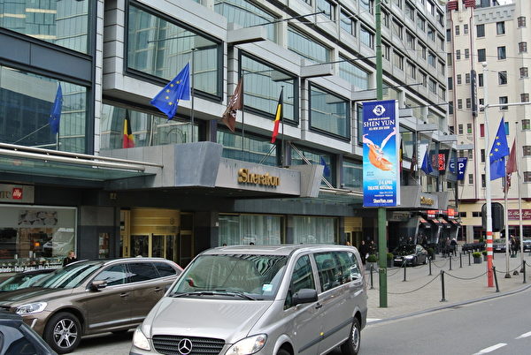 從4月2日至6日，神韻藝術團將在比利時著名的布魯塞爾國家劇院進行六場演出。神韻演出廣告也遍及布魯塞爾的繁華街區。習近平即將下榻Rogier Place廣場附近的喜來登酒店，一張神韻的廣告牌正好被貼在該酒店正對面的一個柱子上，距離該酒店正門口不足5米。（蕭然／大紀元）