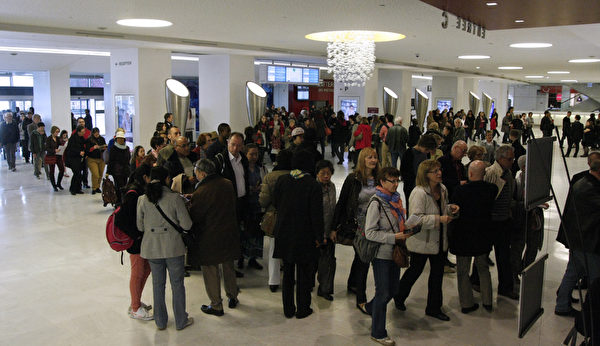 神韻世界藝術團2014年巡演在巴黎的第二場演出3月29日下午在巴黎國際會議中心舉行。觀眾如潮。圖為演出開始前，觀眾排起長龍，等待入場。（章樂/大紀元）


