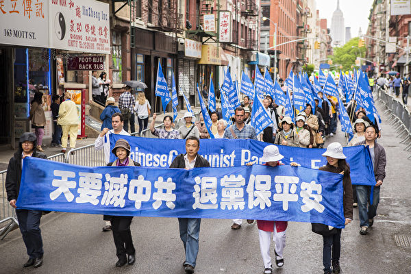 2013年5月18日，紐約曼哈頓，來自世界各地的法輪功學員舉行慶祝法輪大法弘傳21週年大遊行。圖為遊行中的「三退保平安」方陣，「天要滅中共 退黨保平安」的橫幅。（愛德華／大紀元）