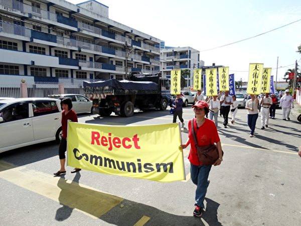 参与游行的义工们手持多幅横幅，声援三退的同时也提醒国人共产党的邪恶本质，引起许多民众和驾驶人士的关注。（杨晓慧/大纪元）
