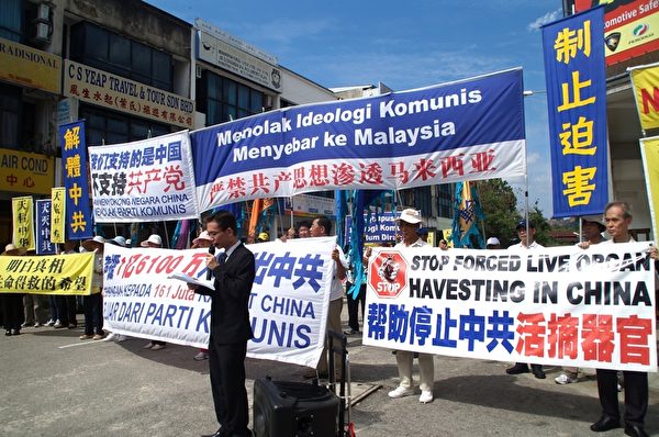 在遊行開始前，馬來西亞退黨服務中心首先舉行集會。圖為退黨服務中心馬來文發言人郭先生宣讀文告。（滕飛/大紀元）