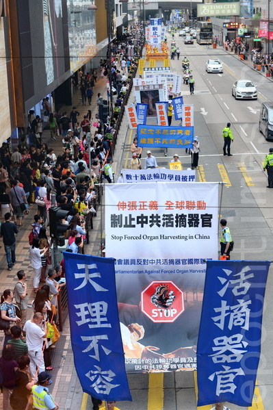 香港法輪功學員20日在長沙灣舉行「四二五」15周年反迫害集會遊行，途中經過市中心旺角、尖沙咀，吸引了大批港民和大陸遊客觀看。（宋祥龍／大紀元）