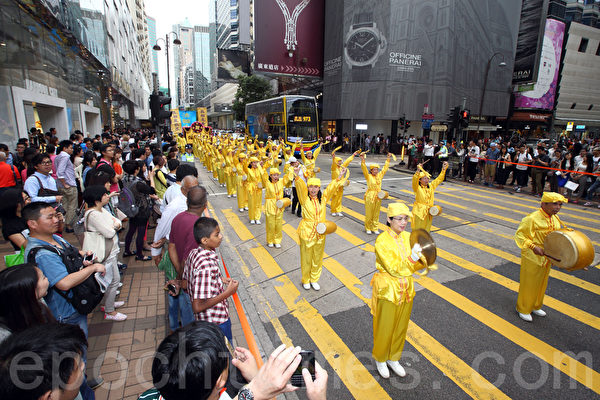 香港法轮功学员4月20日举行声势浩大的游行，纪念“四．二五”和平大上访15周年，大约八百人游行队伍沿着九龙的闹市区，途经多个大陆游客购物热点，吸引两旁的大批游客观看，许多人拿着手机和相机争相拍摄。（潘在殊／大纪元）