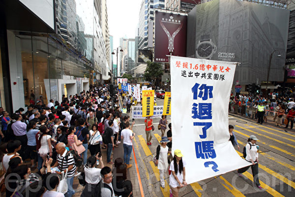 香港法輪功學員4月20日舉行聲勢浩大的遊行，紀念「四．二五」和平大上訪15週年，大約八百人遊行隊伍沿著九龍的鬧市區，途經多個大陸遊客購物熱點，吸引兩旁的大批遊客觀看，許多人拿著手機和相機爭相拍攝。（潘在殊／大紀元）