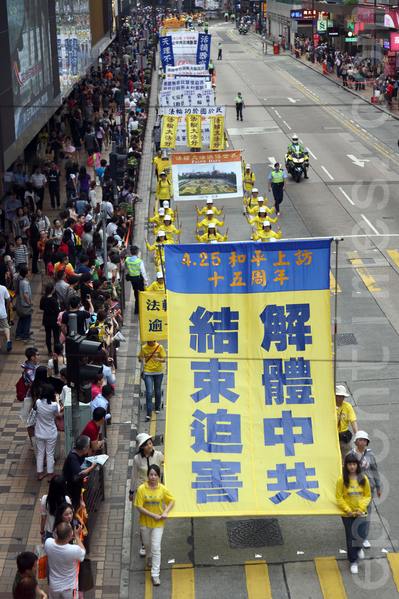 香港法轮功学员4月20日举行声势浩大的游行，纪念“四．二五”和平大上访15周年，大约八百人游行队伍沿着九龙的闹市区，途经多个大陆游客购物热点，吸引两旁的大批游客观看，许多人拿着手机和相机争相拍摄。（潘在殊／大纪元）