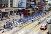 香港法輪功學員4月20日舉行聲勢浩大的遊行，紀念「四．二五」和平大上訪15周年，大約八百人遊行隊伍沿著九龍的鬧市區，途經多個大陸遊客購物熱點，吸引兩旁的大批遊客觀看，許多人拿著手機和相機爭相拍攝。（潘在殊／大紀元）