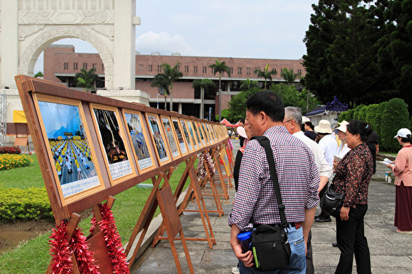 2014年4月26日，台湾法轮功学员于台北中正纪念堂、自由广场进行排字活动，并对来往民众洪法、讲真相。图为民众正在专心阅览正法之路图片展。（罗正恒／大纪元）