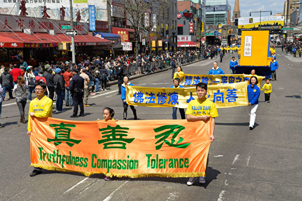 2014年4月26日，紐約法拉盛，上千名法輪功學員舉行了一場聲勢浩大的遊行和集會。圖為遊行中的橫幅。（戴兵／大紀元）