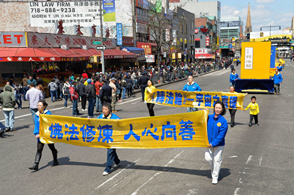 2014年4月26日，紐約法拉盛，上千名法輪功學員舉行了一場聲勢浩大的遊行和集會。圖為遊行中的橫幅。（戴兵／大紀元）