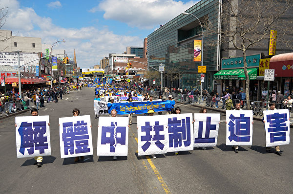 2014年4月26日，紐約法拉盛，上千名法輪功學員舉行了一場聲勢浩大的遊行和集會。圖為「解體中共 制止迫害」的大型展板。（戴兵／大紀元）