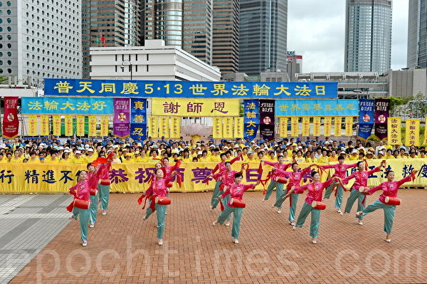 香港法輪功學員在中環舉行慶祝2014年世界法輪大法日及祝賀師尊華誕集會及遊行。圖為學員以歌舞方式向師尊慶祝生日快樂。（宋祥龍/大紀元）