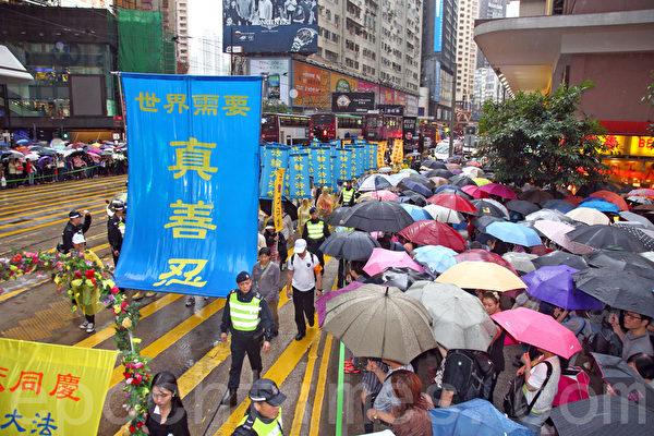 六百多名香港及來自亞洲地區的法輪功學員5月10日冒雨遊行，慶祝法輪大法洪傳世界22週年，希望將法輪大法的美好傳給世人，並呼籲民眾三退“解體中共”，制止中共活摘人體器官等暴行。聲勢浩大的遊行隊伍途徑港島的鬧市區，吸引許多市民和大陸遊客撐著傘在路旁觀看。（潘在殊/大紀元）