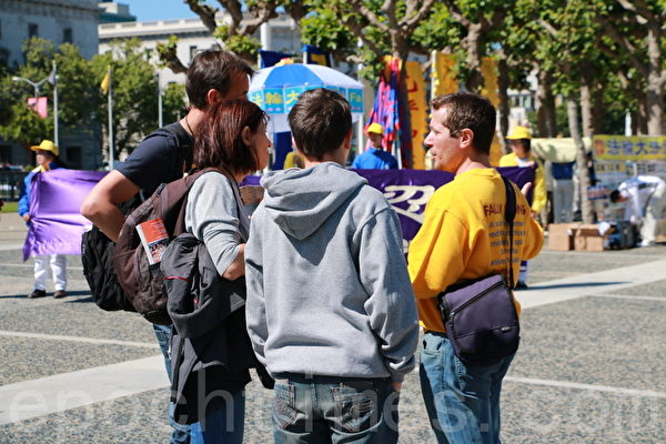 5月10日（週六），來自舊金山灣區的法輪功學員在舊金山舉行遊行活動，慶祝5.13世界法輪大法日的到來。圖為法輪學員向遊客介紹法輪功。（曹景哲/大紀元）