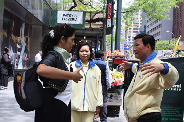 2014年5月14日法轮功学员纽约大游行。法轮功游行队伍震撼了纽约人，有位女士当场跟台湾来的法轮功学员学习炼功动作。（骆亚/大纪元）