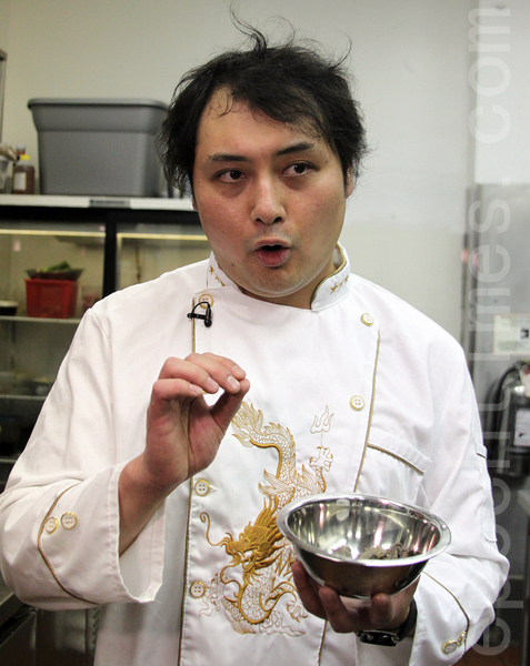 萬錦市中餐廳「城南往事」廚師呂偉手拿一盤海參，向媒體介紹他的參賽菜蔥燒海參。 （周月諦／大紀元）