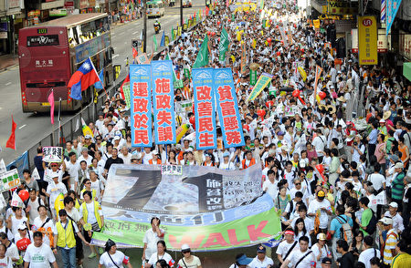 2009年七一大游行的主题为“施政失误、贫富悬殊、还政于民、改善民生”。图为2009年7月1日，香港，参加游行的队伍。（MIKE CLARKE／AFP)