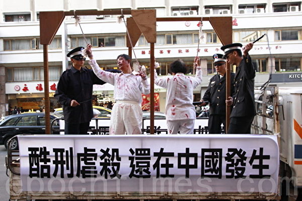 1999年7月20日，中共江澤民集團發動了對法輪功團體從肉體上、精神上及經濟上的全面系列的殘酷迫害。圖為2010年12月18日，台灣舉行「呼喚良知 停止迫害」大遊行中，模擬中共使用酷刑迫害法輪功學員。（林伯東／大紀元）