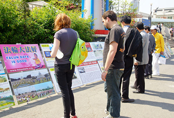 2012年5月6日，韩国各界在首尔站前广场庆祝世界法轮大法日。市民们通过真相图片展板在了解法轮功真相。（金国焕/大纪元）