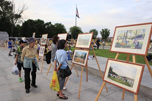 2012年7月13日，美国华盛顿DC，法轮功真相图片展的现场，民众正在看真相图片。（大纪元）
