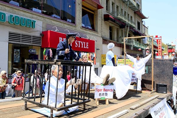 2013年7月21日，美国旧金山，法轮功学员举行反迫害十四周年大游行，队伍中演示中共以各式酷刑迫害法轮功学员。（大纪元）
