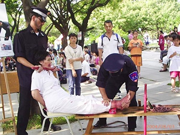 2004年10月10日，台湾高雄，法轮功学员市举办“反迫害真人演示酷刑展及图展”，呼吁制止中共江氏集团迫害法轮功学员的暴行。（明慧网）