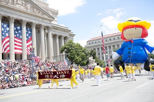法輪功參加美國首都華盛頓DC的憲法大道上舉行的獨立紀念日遊行，法輪大法旗幟在前引導隊伍前進。（李莎/大紀元）