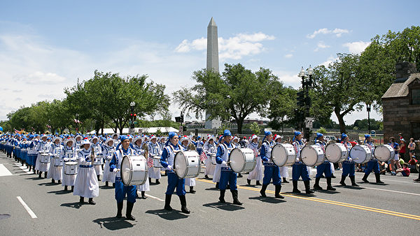 法輪功學員組成的天國樂團參加2014年美國首都華盛頓DC的獨立日慶祝遊行，整齊的隊伍與氣勢恢宏的樂曲獲得民眾熱烈掌聲。（李莎/大紀元）