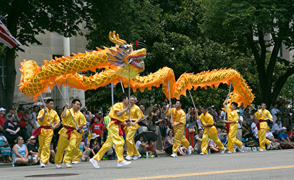 法輪功參加美國首都華盛頓DC的獨立日慶祝遊行，其中由13名法輪功學員組成的舞龍隊，在現場有如一條黃色巨龍在穿梭飛騰，成爲當日遊行中的亮點。（李莎/大紀元）