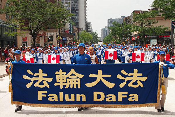 加拿大國慶日遊行隊伍中，最引人注目的當屬這支由100多名法輪功學員組成的天國樂團。不少觀眾甚至是專程前來觀看這個身著藍白色中國傳統服飾的軍樂隊遊行隊伍。（Nathalie Dieul/大紀元）