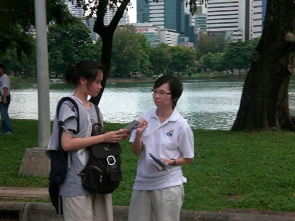 泰國法輪功學員在向遊人介紹法輪大法。(大紀元圖片)