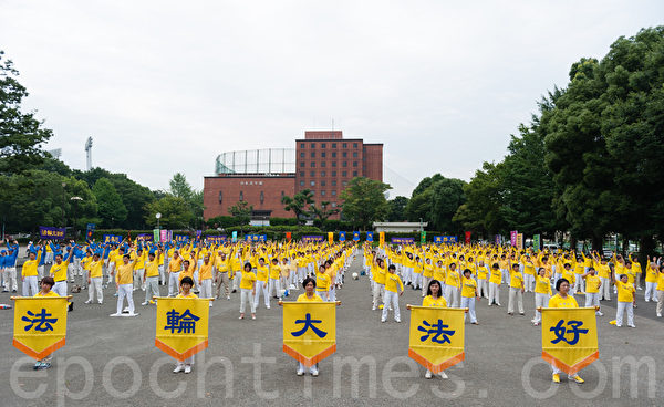 7月13日亚洲地区的部分法轮功学员汇聚东京举行反迫害15年的集会游行活动。游行当日的上午，逾千法轮功学员集体炼功，展示五套功法。（大纪元/游沛然）