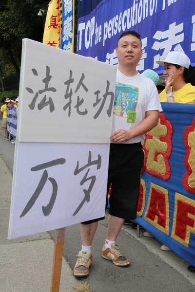 圖：大陸移民王先生自已製作了一個一人高的牌子，上面寫著「法輪功萬歲」。他認為法輪功是全球華人中最優秀的團體。（田園/大紀元）