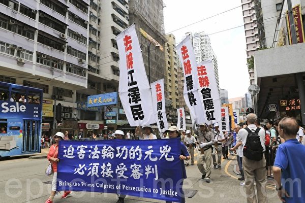 在法轮功反迫害15周年之际，香港法轮功学员举行“全球联动 制止迫害”游行与集会活动，（19日）是活动首日，下午1时30分，逾九百名香港和海外法轮功学员由北角英皇道游乐场出发，游行至政府总部外举行盛大集会，呼吁“解体中共，结束迫害”，并宣布反对中共活摘器官国际联盟成立。（余钢/大纪元）